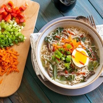Bowl of Homemade Ramen with cutting board with toppings