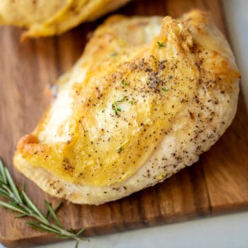 Baked Chicken Breast on Wooden Cutting board.