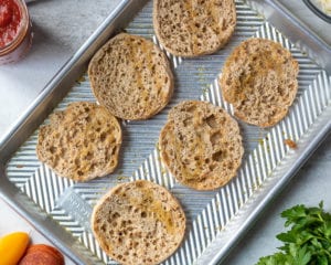 Tray of English Muffin Halves with brushed with garlic oil