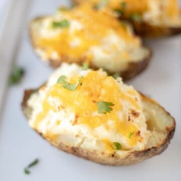 Double Stuffed Potato topped with cheese on white plate