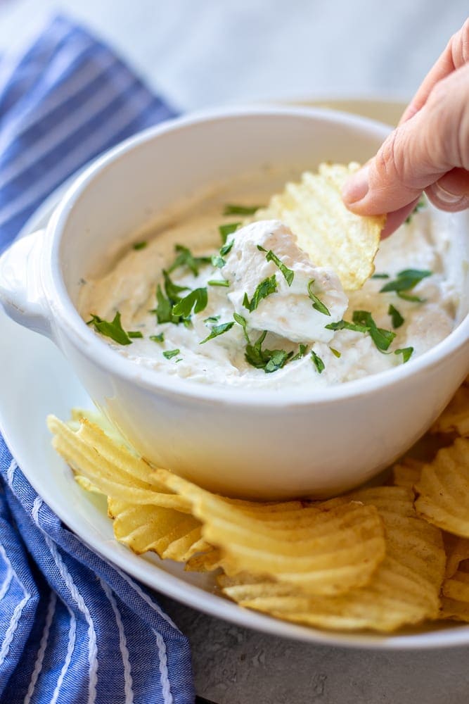 Potato Chip dipping into french onion chip dip