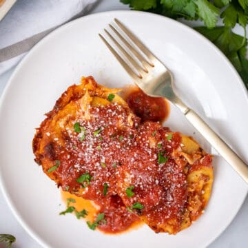Plate of baked ravioli with fork on plate.