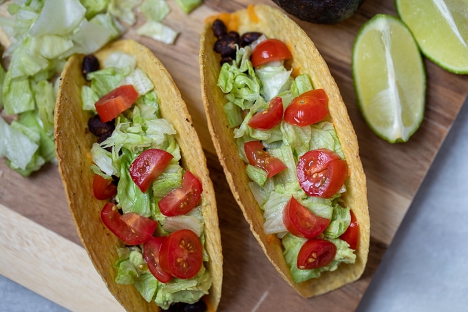 Black Bean Tacos topped with lettuce, avocado, and tomatoes