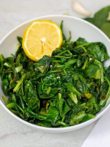 Bowl of wilted sauteed spinach with lemon