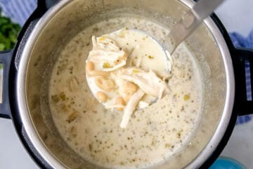 Ladle of white chicken chili coming out of the instant pot.