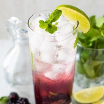 Glass of blackberry mojito garnished with mint leaves