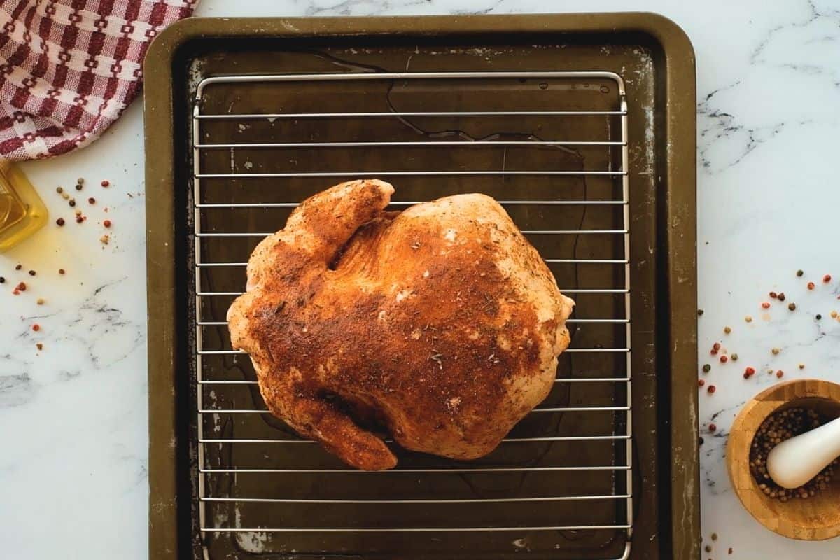 Seasoned chicken on roasting pan. 