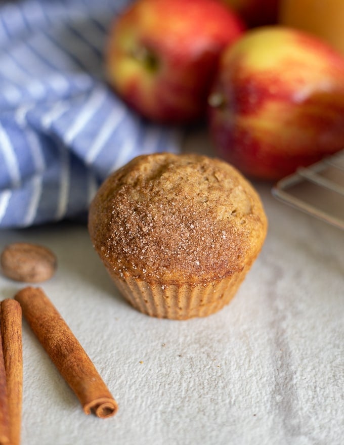 Applesauce Muffin next to fresh apples and blue napkin.