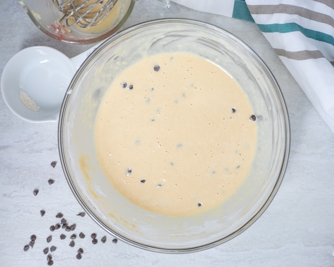 Pancake batter with chocolate chips in glass bowl