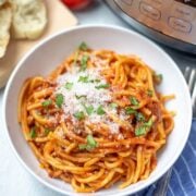 Bowl of Instant Pot Spaghetti next to Electric Pressure Cooker