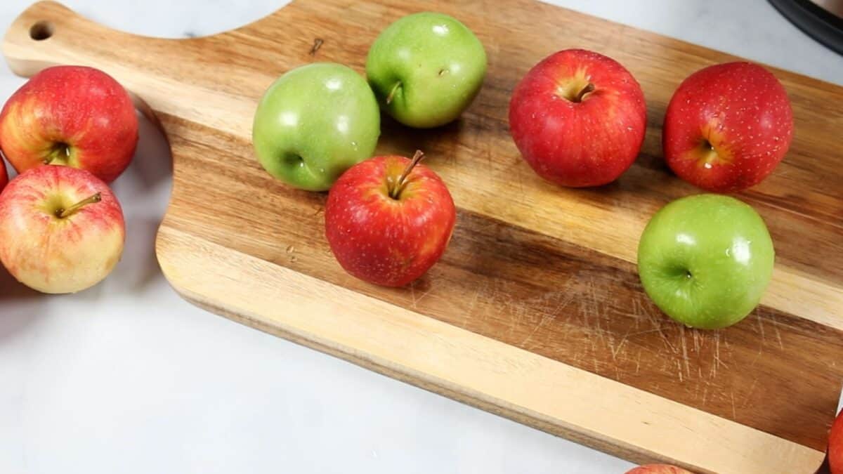 Variety of apples on cutting board.