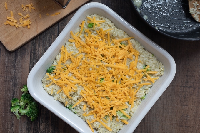 Broccoli Casserole in white dish topped with cheese.
