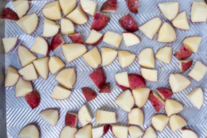 Sheet pan with potatoes spread out evenly.