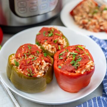 Instant Pot Stuffed peppers on white plate next to Instant Pot