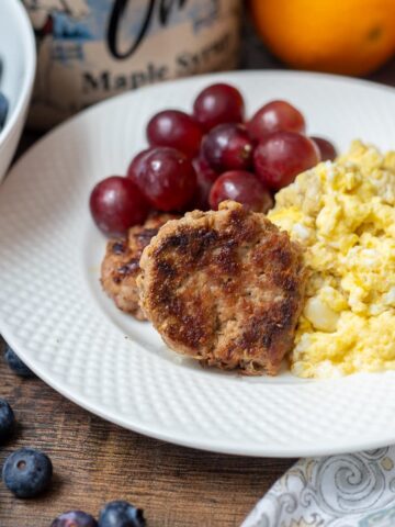 Breakfast Sausage on white plate with scrambled eggs