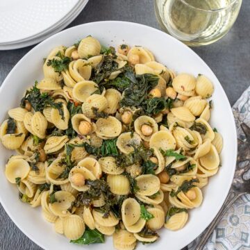 Orecchiette pasta with chickpeas and kale in white dish