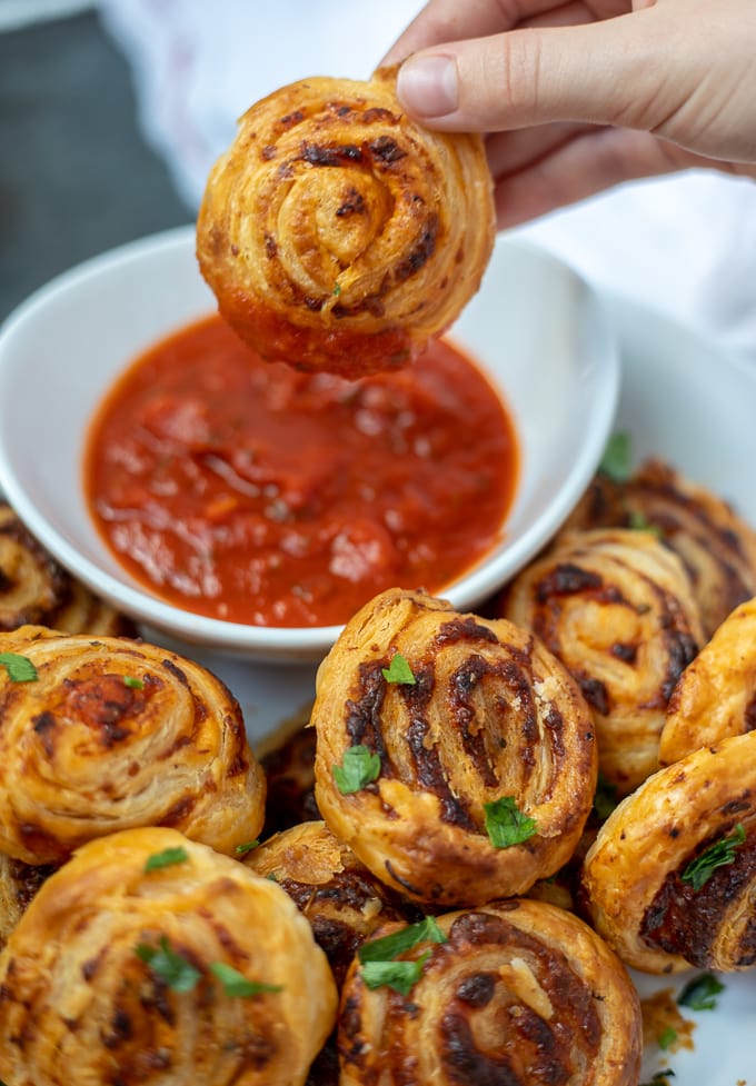 Pizza roll being dipped in marinara sauce