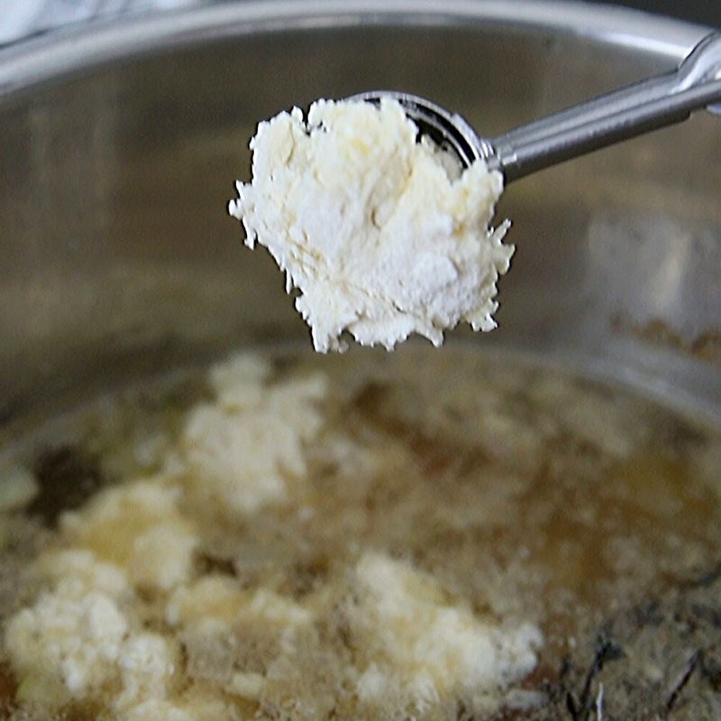 Scoop dropping homemade dumplings into instant pot