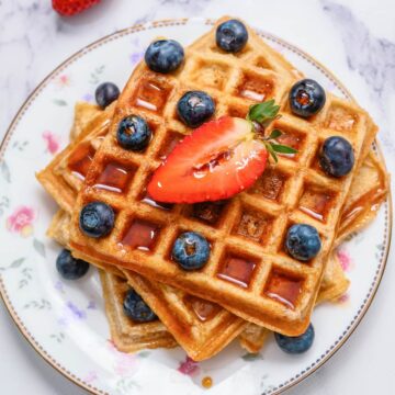 Whole Wheat waffles on plate with berries and syrup