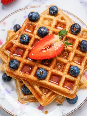 Whole Wheat waffles on plate with berries and syrup