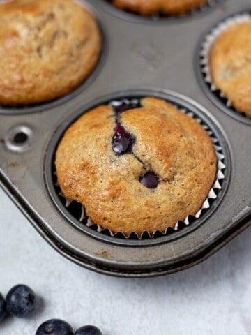 Baked whole wheat blueberry muffins in muffin tin.