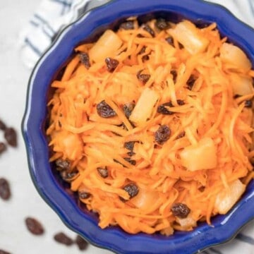 Carrot Raisin Salad with pinepple in a blue serving bowl.
