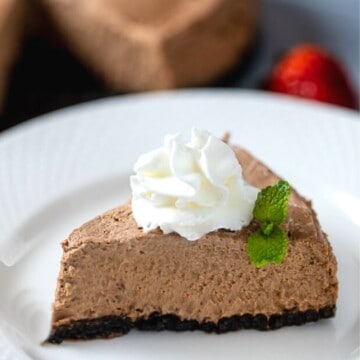 Slice of Instant Pot Chocolate Cheesecake topped with whipped cream.