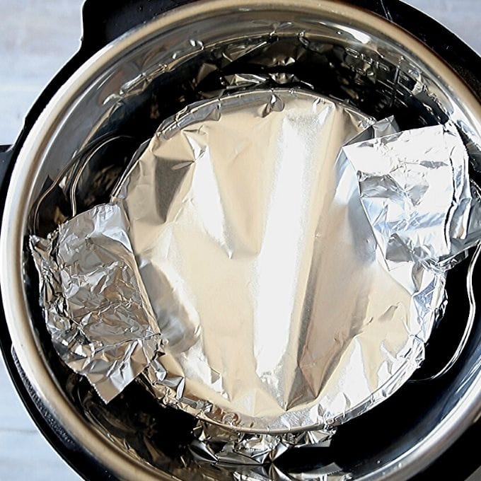 Springform pan wrapped in foil on rack in instant pot