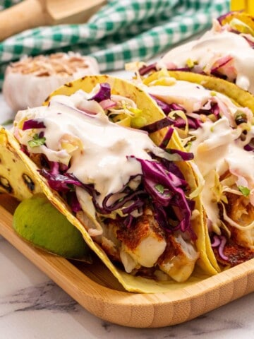 Healthy Fish tacos served with cabbage and crema.