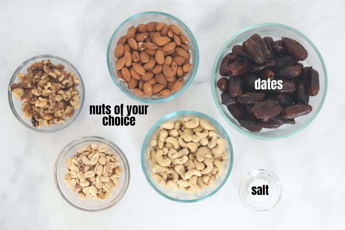 Bowls of dates, almonds, walnuts, cashews, and peanuts on counter. 