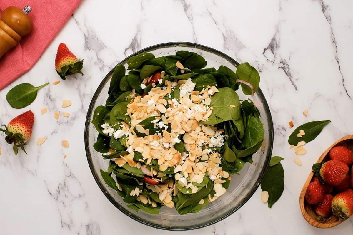 Feta and almonds sprinkled over spinach strawberry salad. 