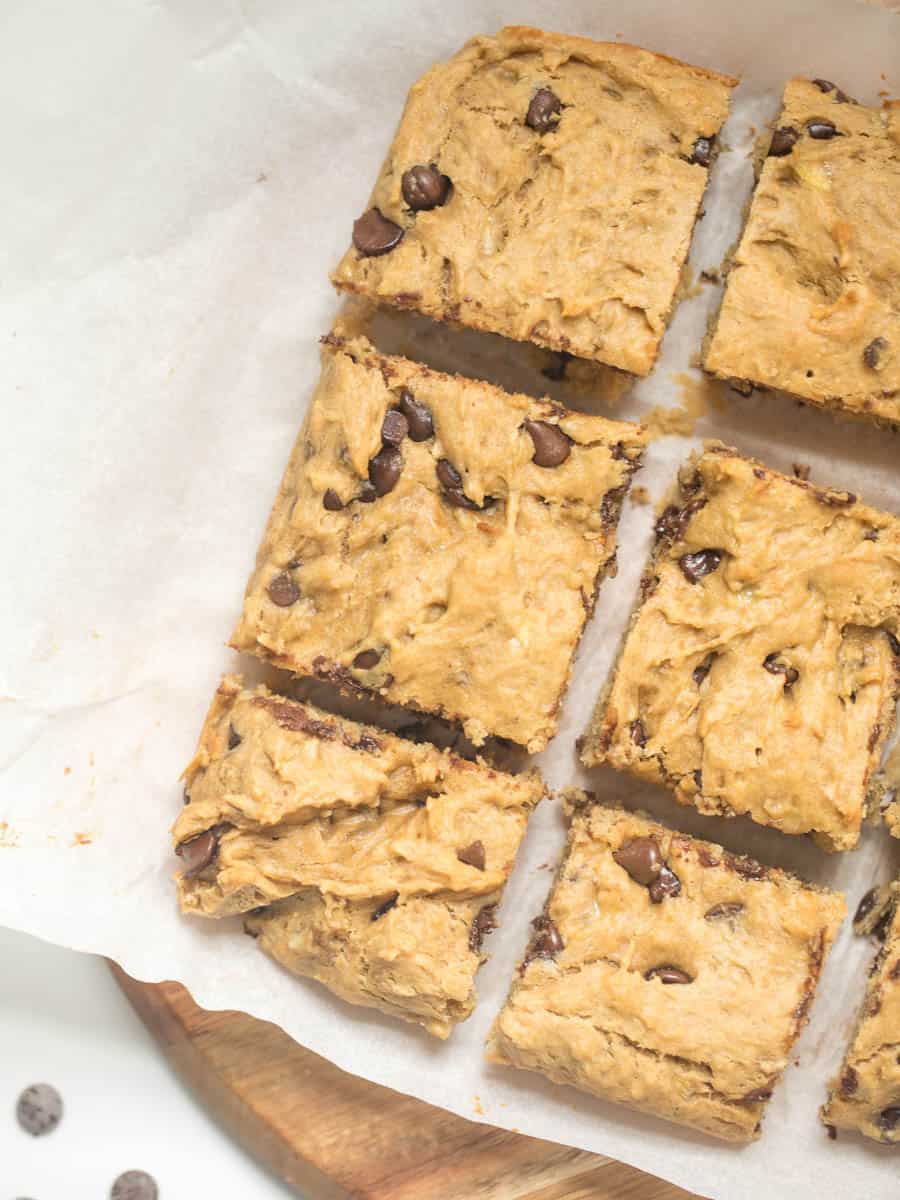 Peanut butter banana chocolate chip bars cut into bars on parchment paper. 