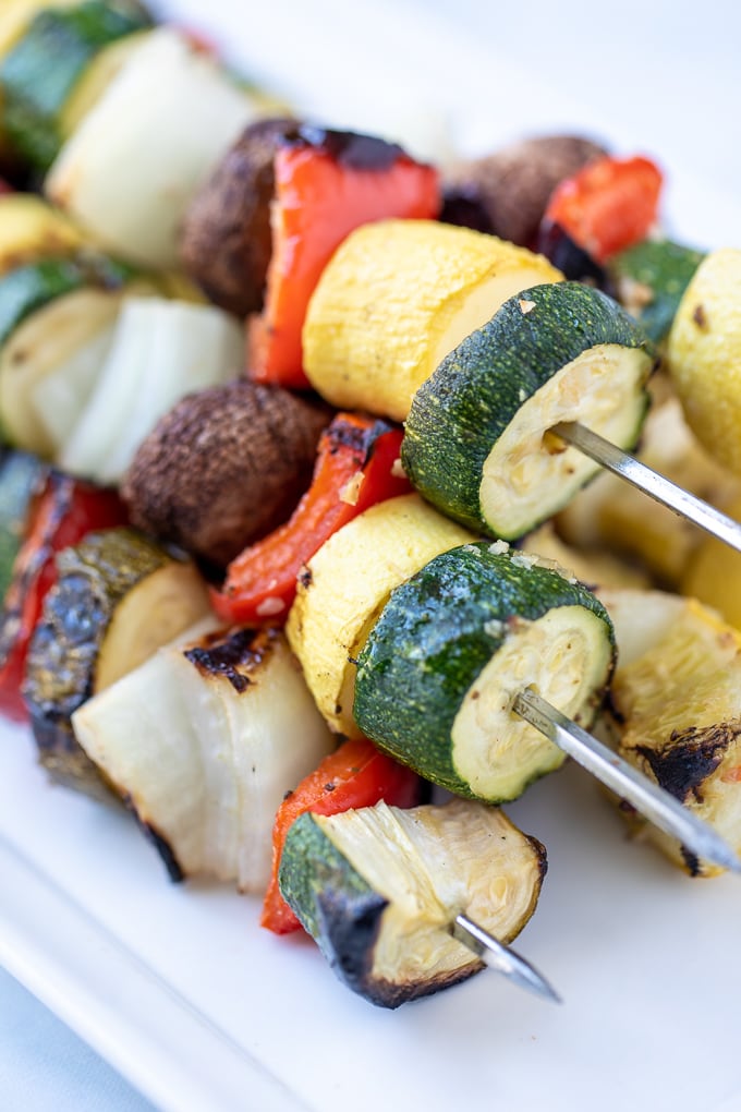 Close up of Grilled Vegetable Kabobs on white platter. 