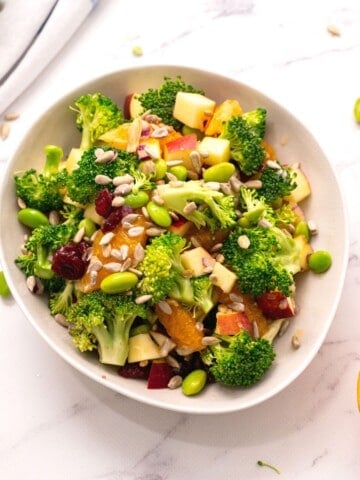 Bowl of healthy broccoli salad next to oranges.