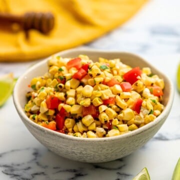 Corn Salsa served in bowl with limes in background.
