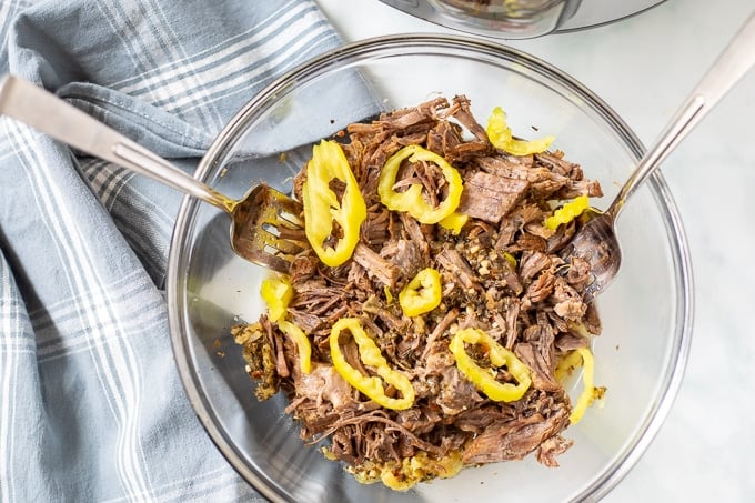 Bowl of Shredded Italian Beef topped with Pepperoncini Peppers.
