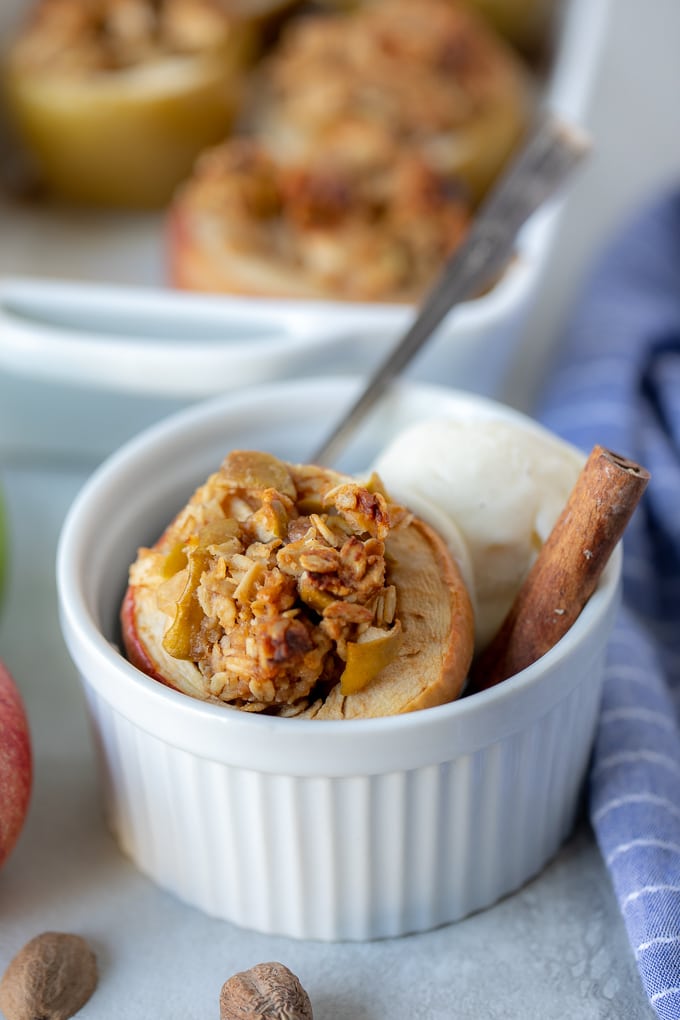 Baked Apple with ice cream in white dish.