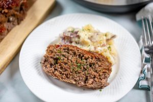 Sliced Meatloaf with mashed potatoes on white plate
