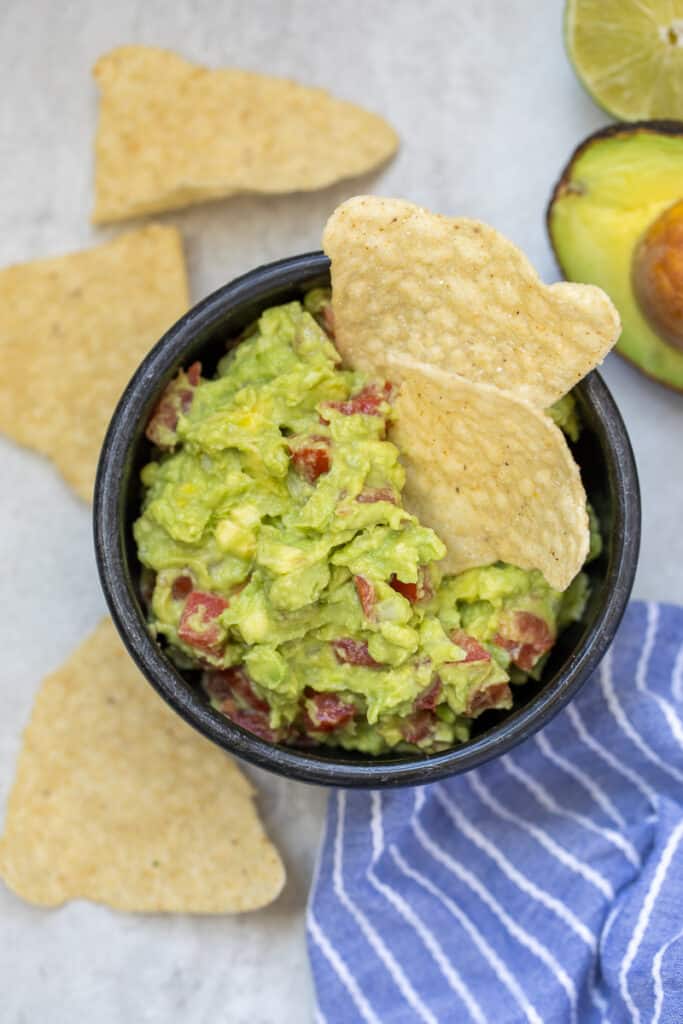 Bowl of Homeamde Guacamole with chips on the side. 