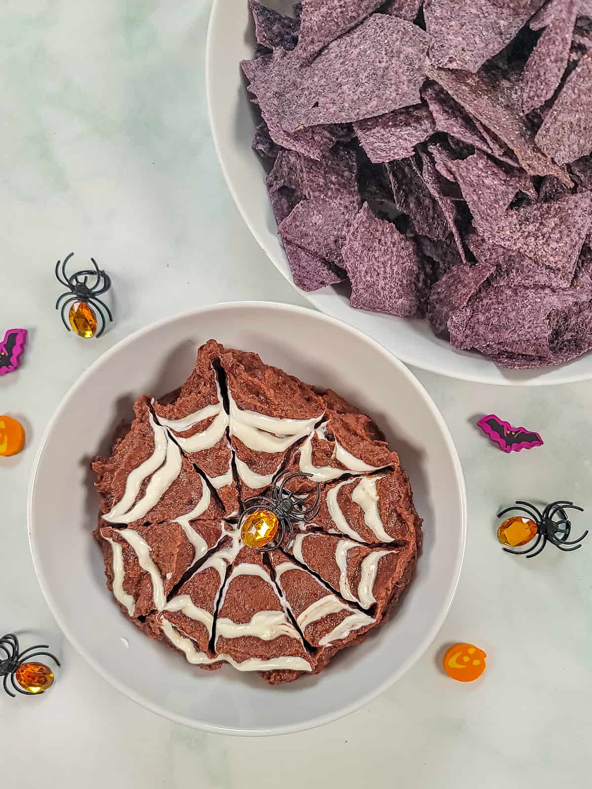 Black bean dip with sour cream spider web piped on it. 