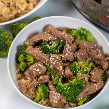 Beef and Broccoli in white bowl topped with sesaame seeds