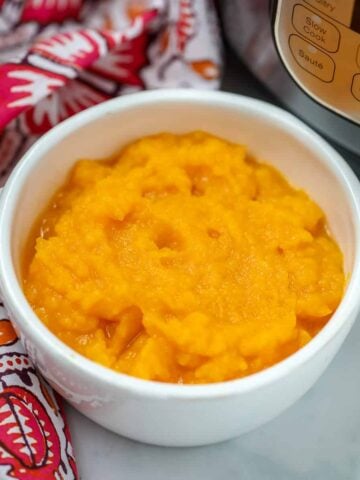 Mashed Instant Pot Butternut Squash in white bowl next to Instant Pot