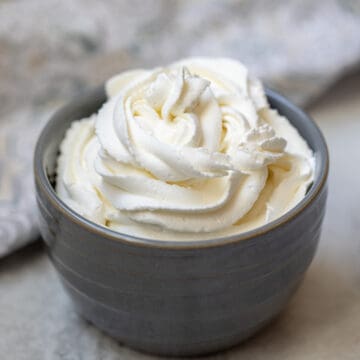 Piped whipped cream in a gray bowl.
