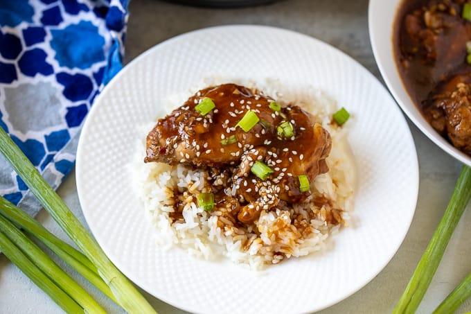 Plate of Instant Pot Chicken Teriyaki served over rice with green onions to the side.