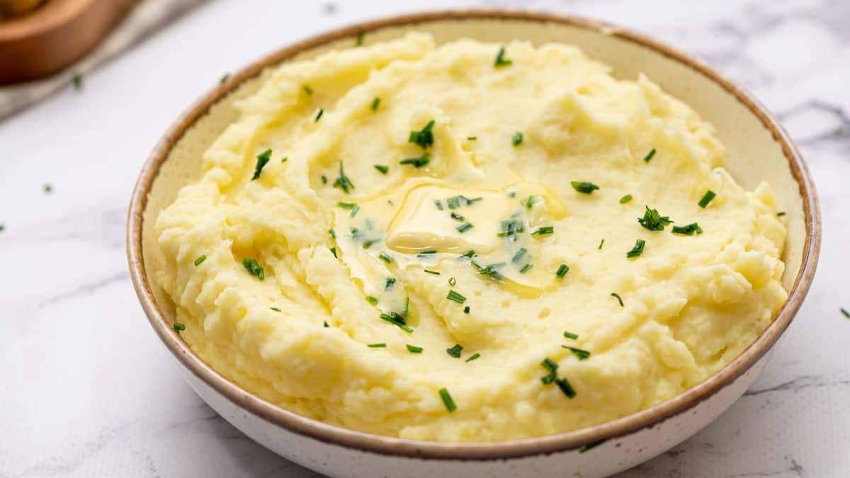 Bowl of Mashed Potatoes topped with butter and chives