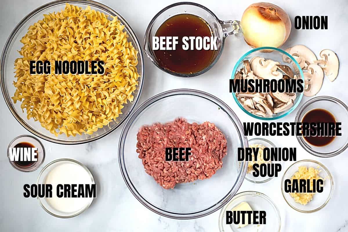 Ingredients for beef stroganoff labeled on white counter.