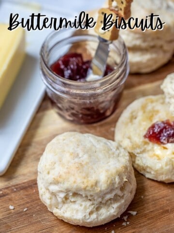Flaky Buttermilk biscuit with jam and butter in background.