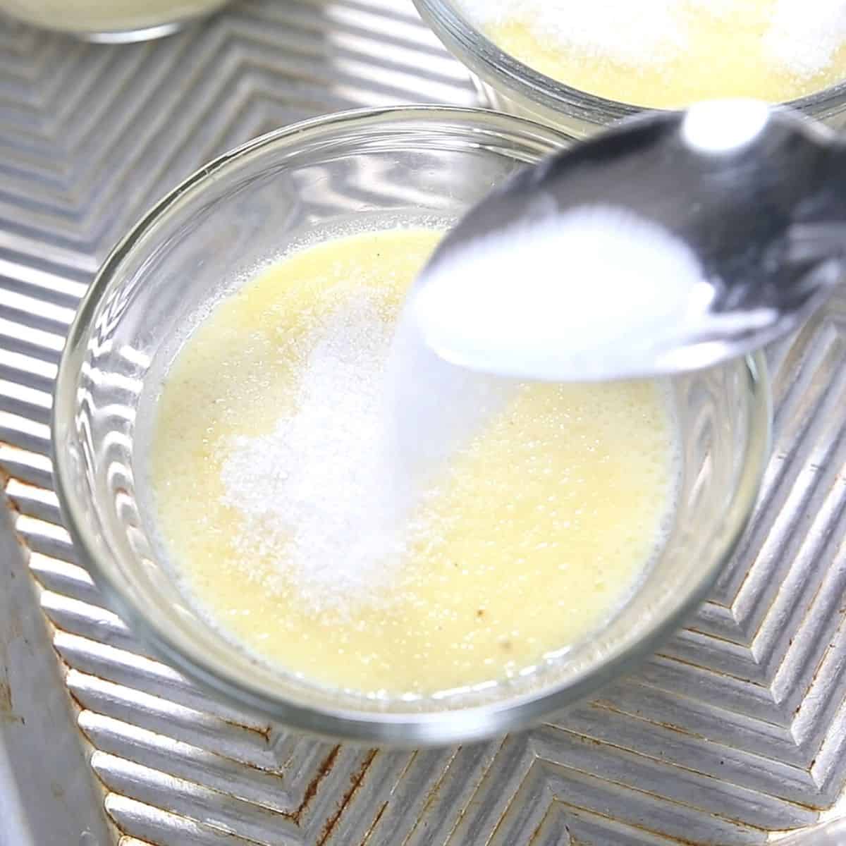 Sprinkling sugar on top of set creme brulee. 