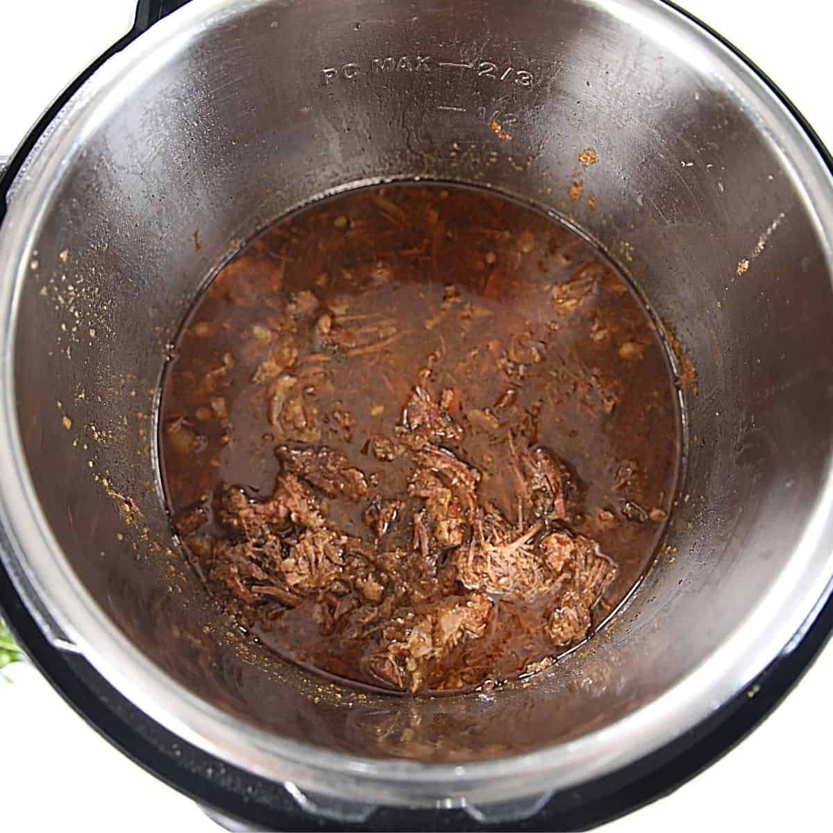 shredded beef in mexican sauce inside inner pot.
