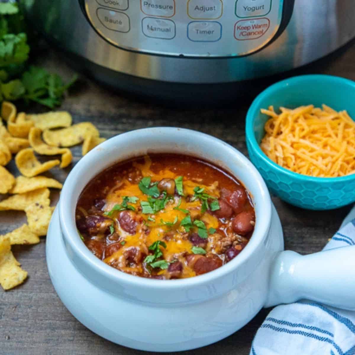 Bowl of chili next to instant pot.
